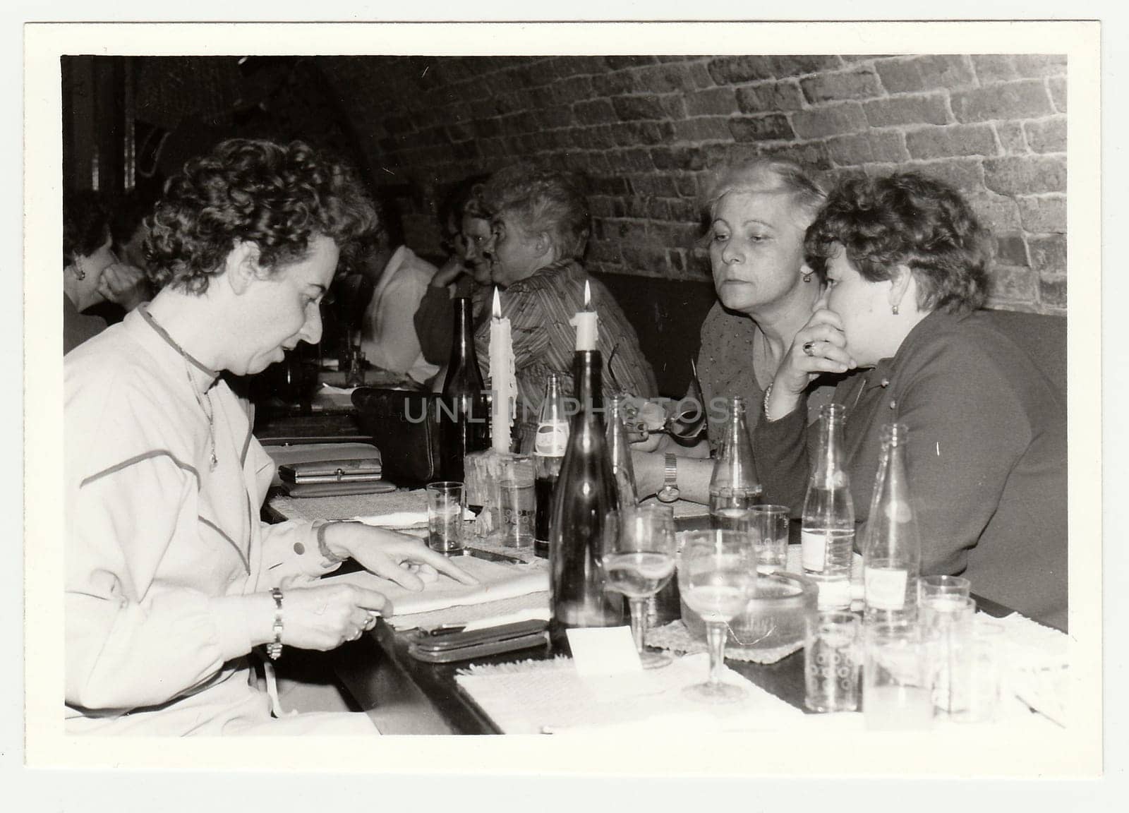 Vintage photo shows a group of people in a wine bar. by roman_nerud