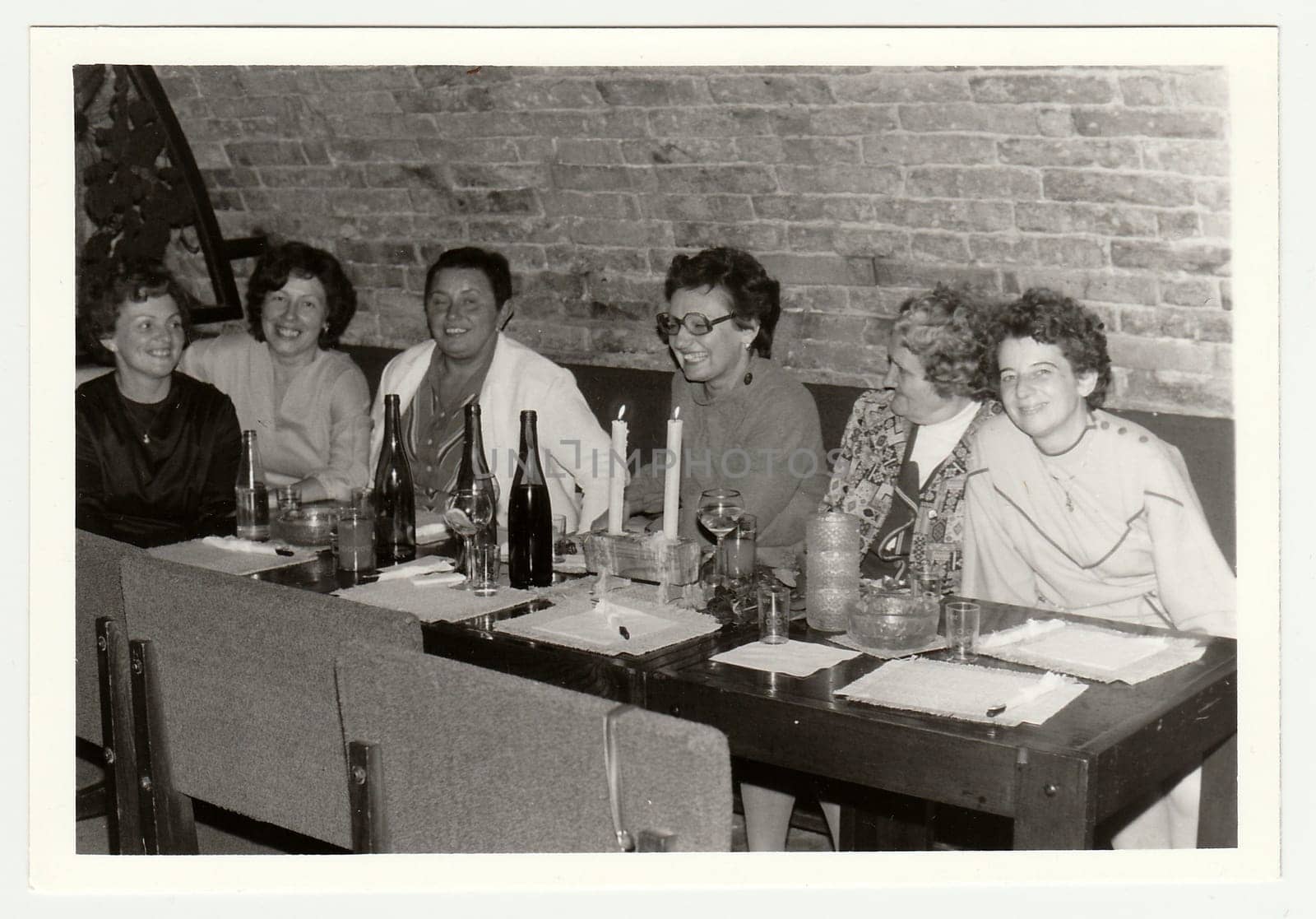 Vintage photo shows a group of people in a wine bar. by roman_nerud