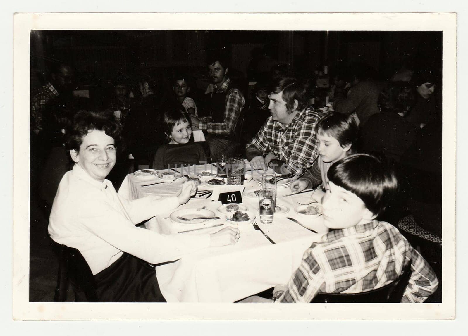 Vintage photo shows a group of people in the restaurant. by roman_nerud