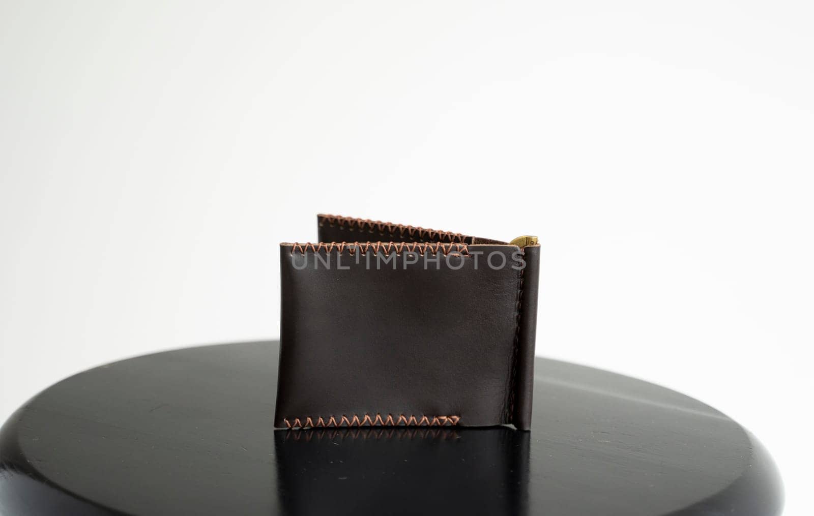 Handmade brown men's money clip handmade leather wallet with a two pockets on a black table