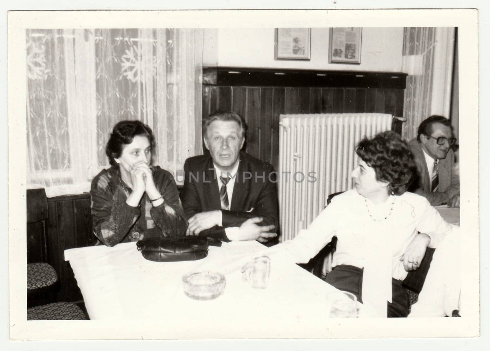 Vintage photo shows a group of people in the restaurant. by roman_nerud