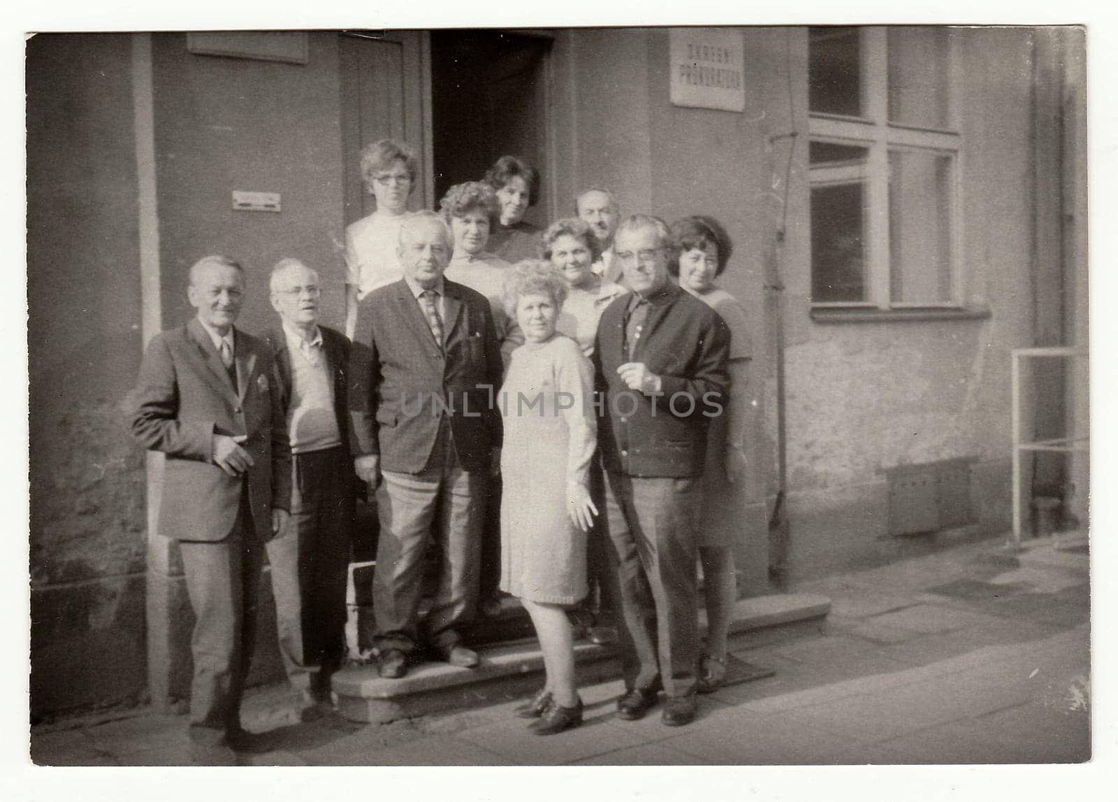 Vintage photo shows group of people in front of building. by roman_nerud