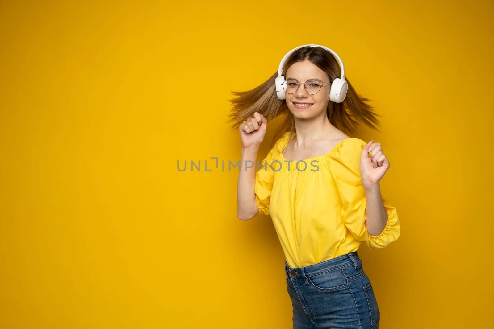 Young beautiful woman in bright outfit enjoying a music. by vovsht