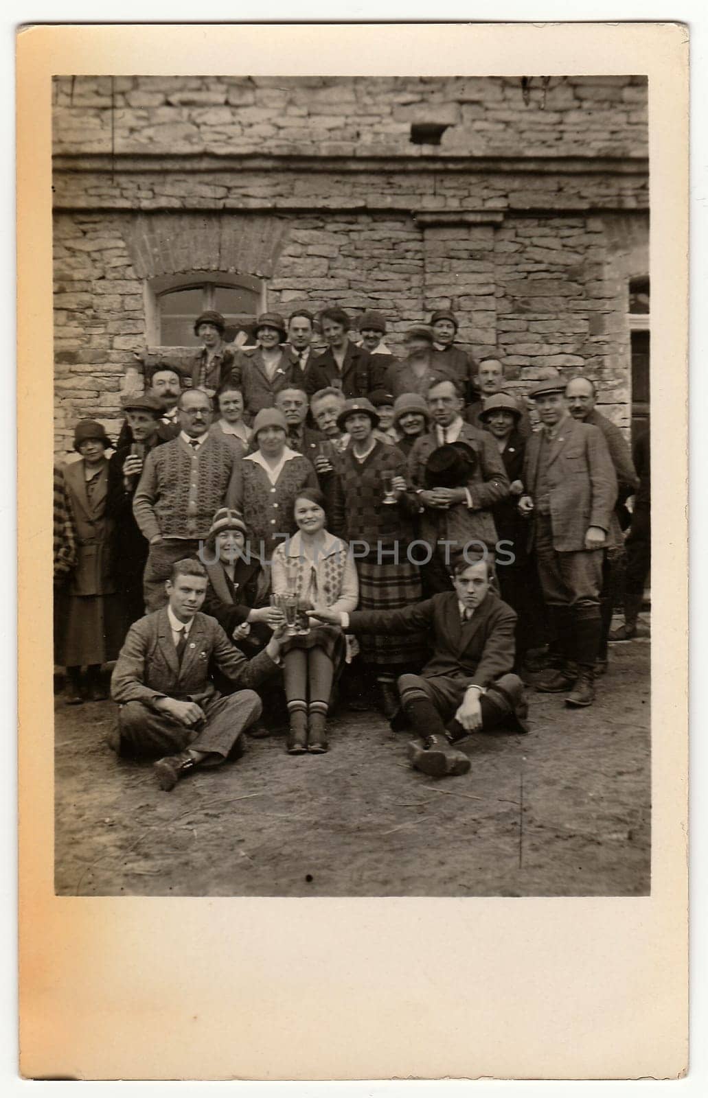 Vintage photo shows people in front of stone built house. by roman_nerud