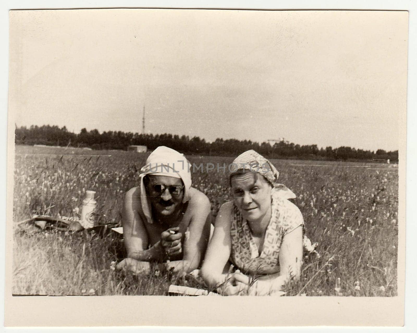 Vintage photo shows a marrital couple have a rest on meadow by roman_nerud