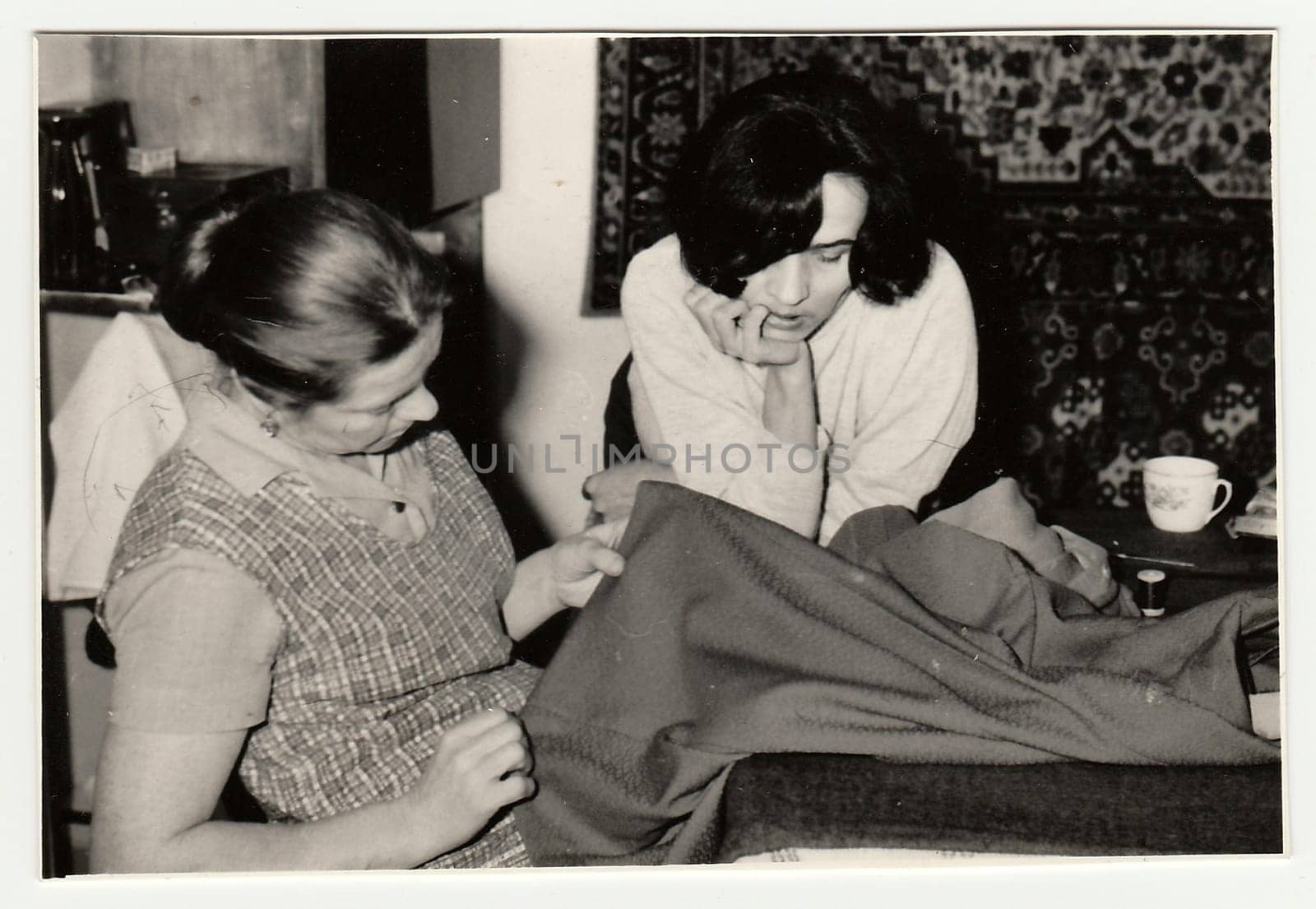 Vintage photo shows women prepare to sew a dress. by roman_nerud