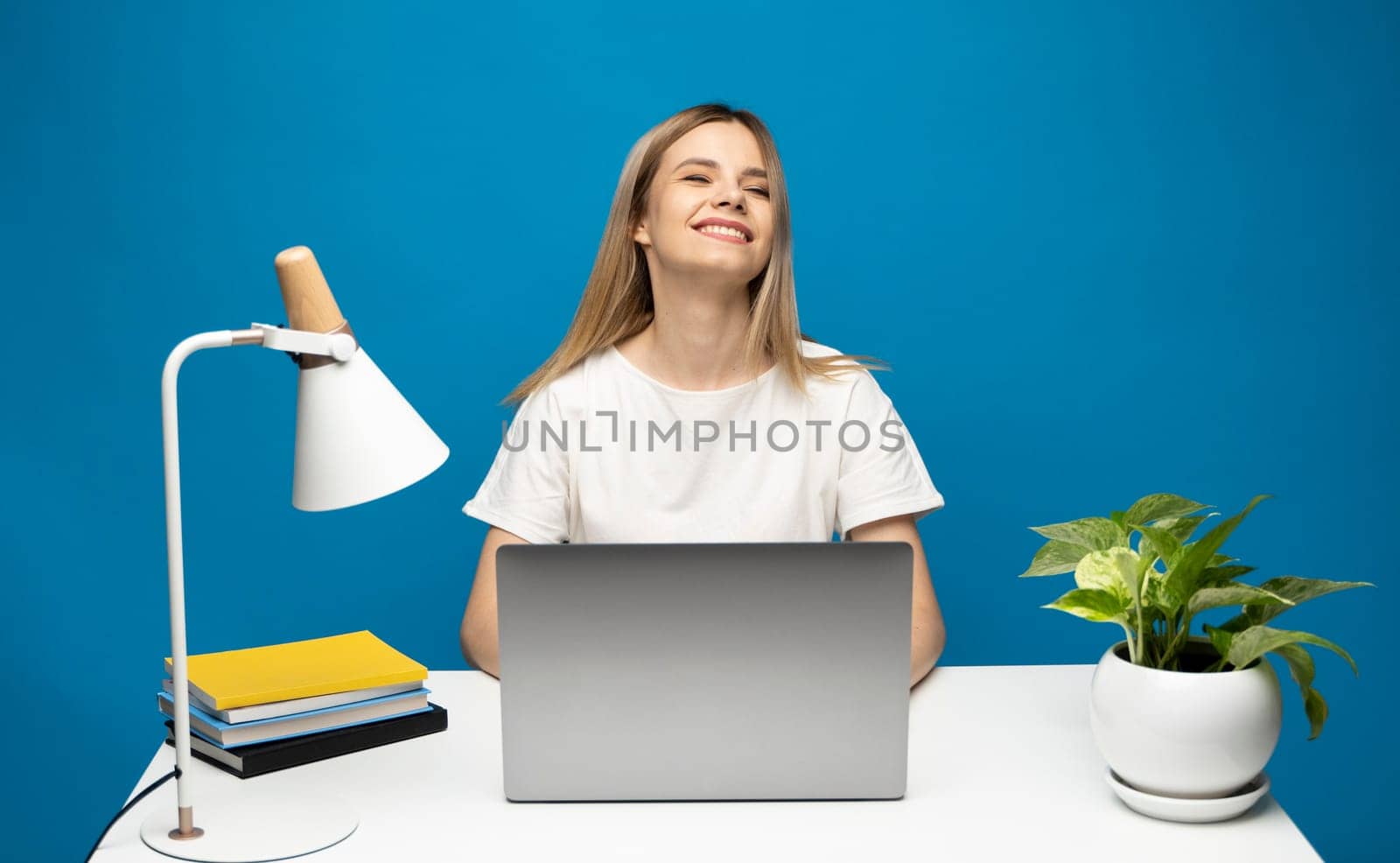 Young successful happy employee business woman in casual white shirt sit work at office desk with pc laptop computer workspace area do winner gesture isolated on blue background studio. by vovsht