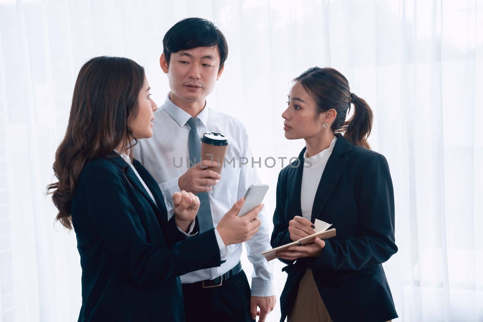 Mentor, manager with coffee advice younger colleagues in workplace. Businesspeople discussing or planning financial project strategy, talking together for harmony and strong teamwork in office concept