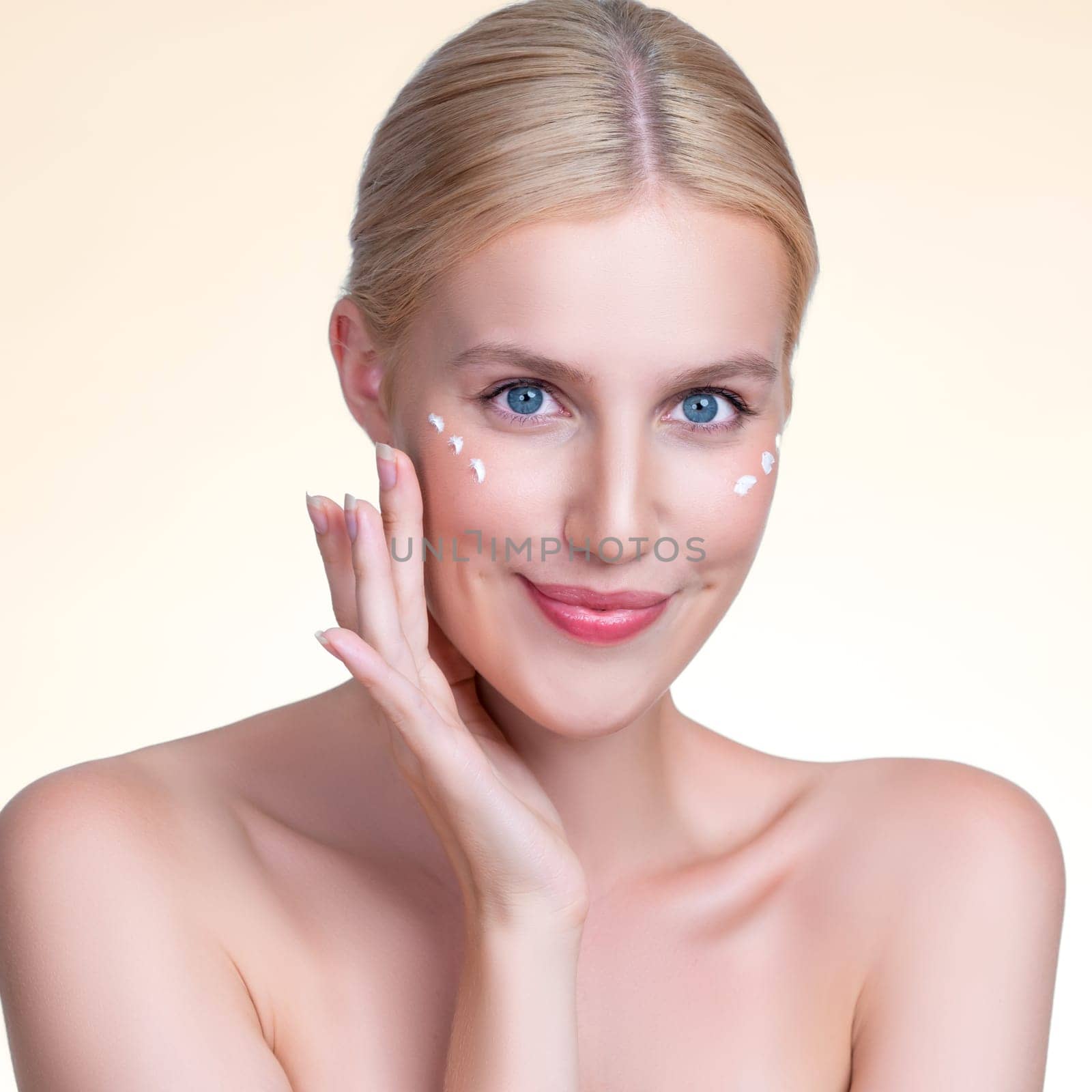 Personable beautiful perfect clean skin soft makeup woman finger applying moisturizer cream on her face under contour eye for anti aging wrinkle. Facial skin rejuvenation in isolated background.