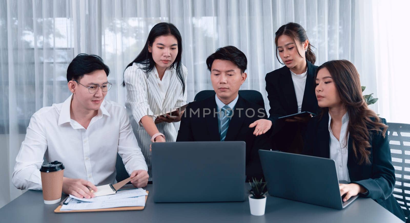 Harmony in office concept as business people analyzing dashboard paper together in workplace. Young colleagues give ideas at manager desk for discussion or strategy planning about project.