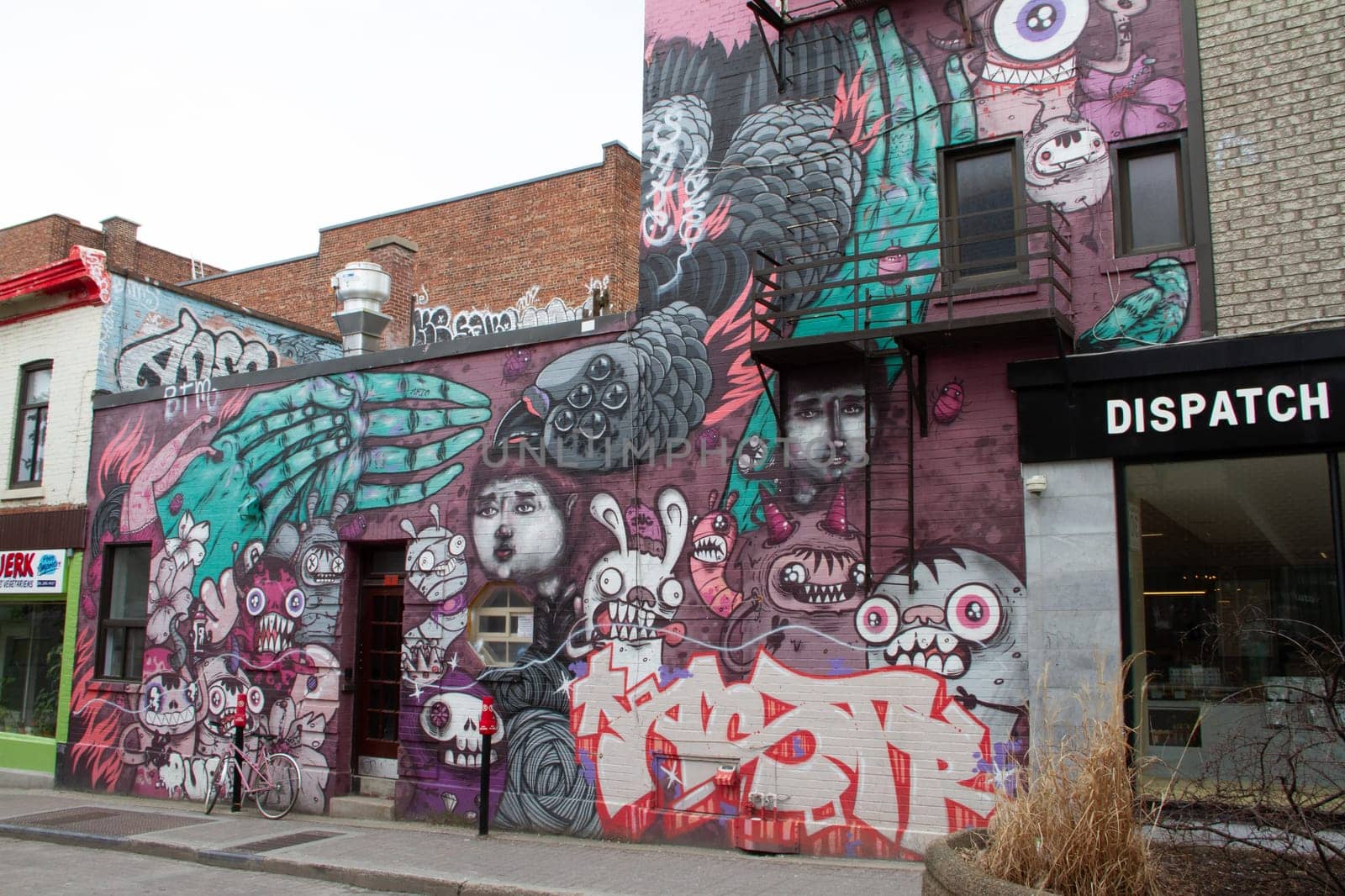 Graffiti street art mural lining a building in a side street of Montreal, Quebec by Granchinho