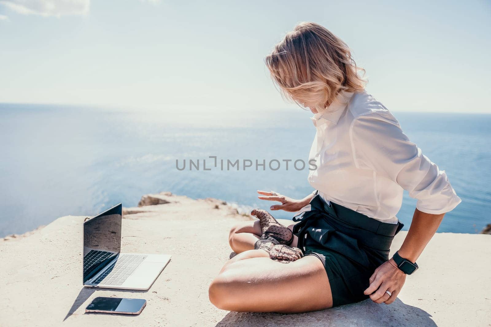 Happy girl doing yoga with laptop working at the beach. beautiful and calm business woman sitting with a laptop in a summer cafe in the lotus position meditating and relaxing. freelance girl remote work beach paradise