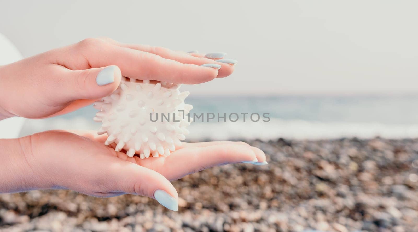 Woman yoga sea. Well looking middle aged woman with braids dreadlocks in white leggings and tops doing stretching pilates on yoga mat near sea. Female fitness yoga routine concept. Healthy lifestyle