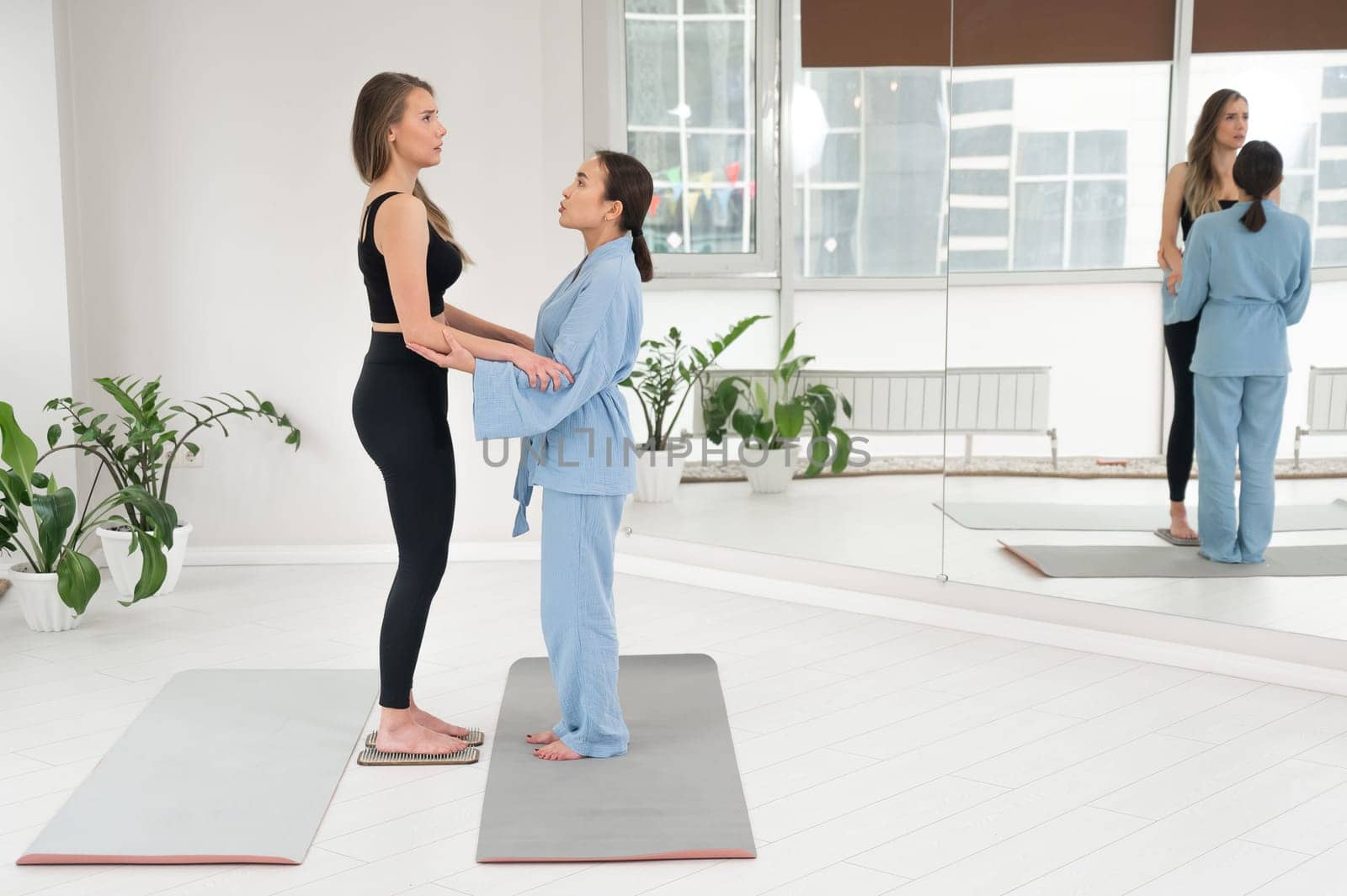 Caucasian woman stands on sadhu boards with therapist support