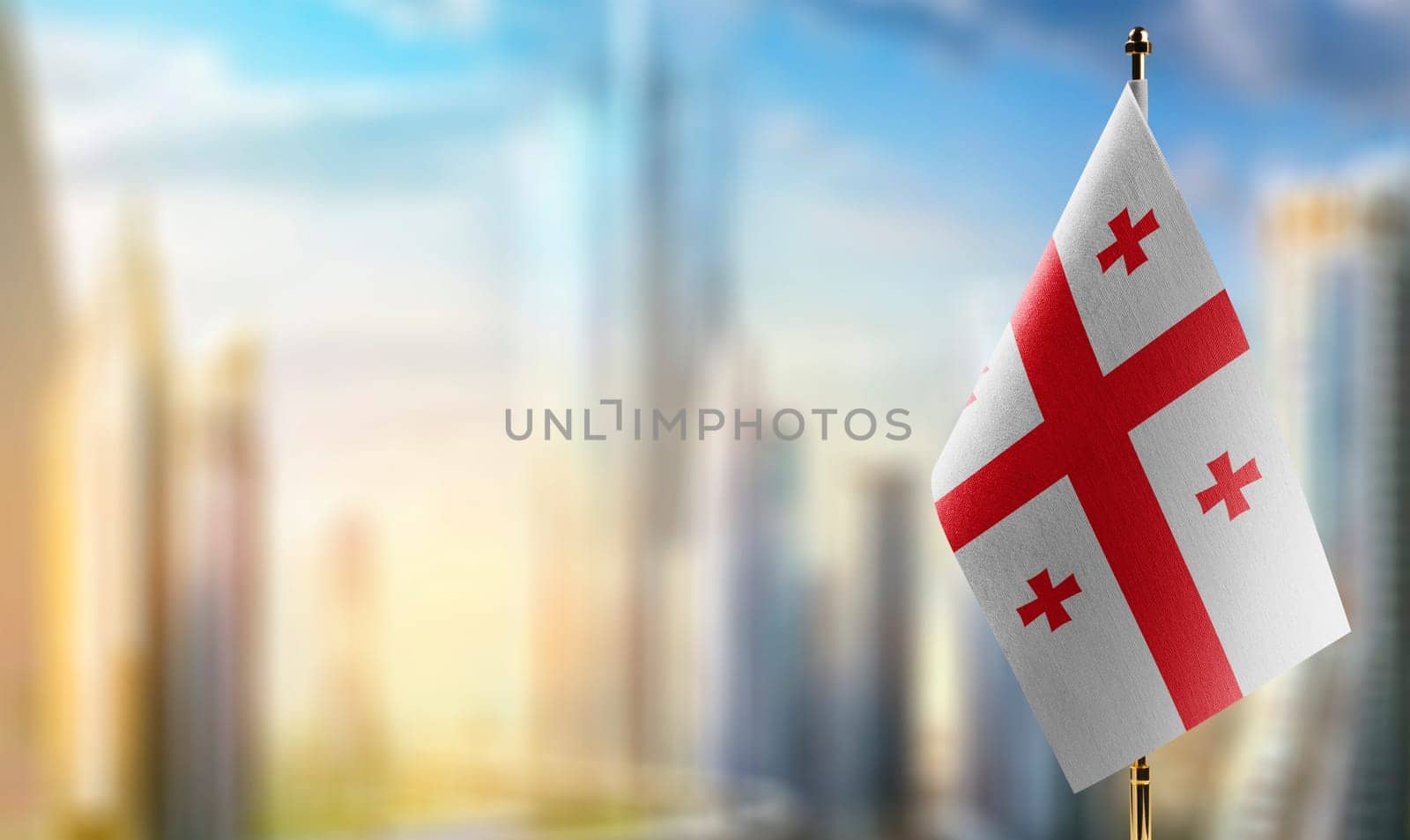 Small flags of the Georgia on an abstract blurry background.
