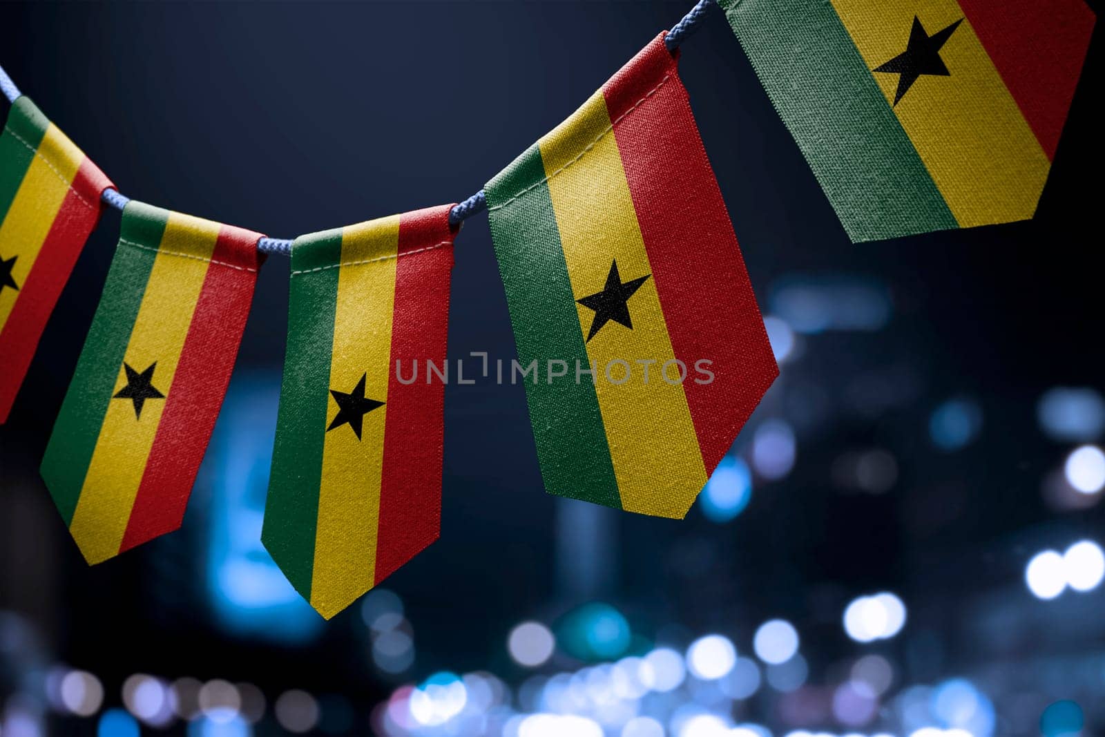 A garland of Ghana national flags on an abstract blurred background.