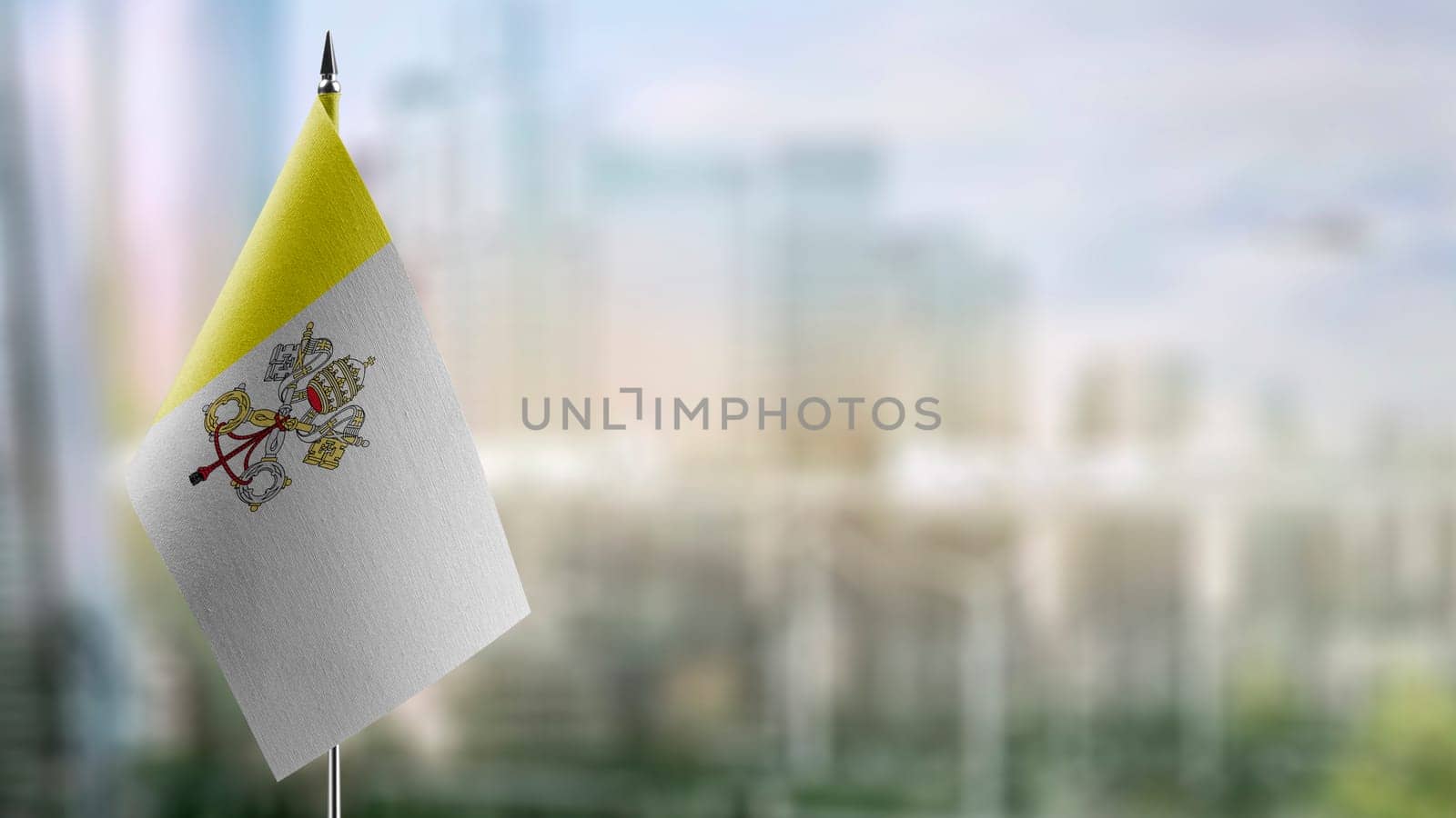 Small flags of the Vatican on an abstract blurry background.
