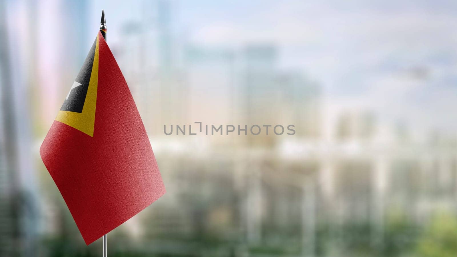 Small flags of the East Timor on an abstract blurry background.