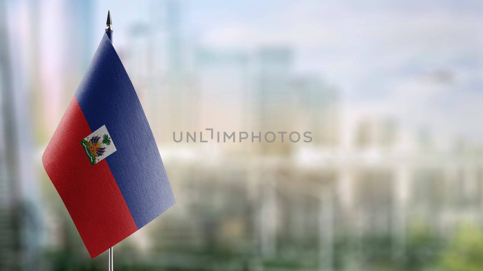 Small flags of the Haiti on an abstract blurry background.