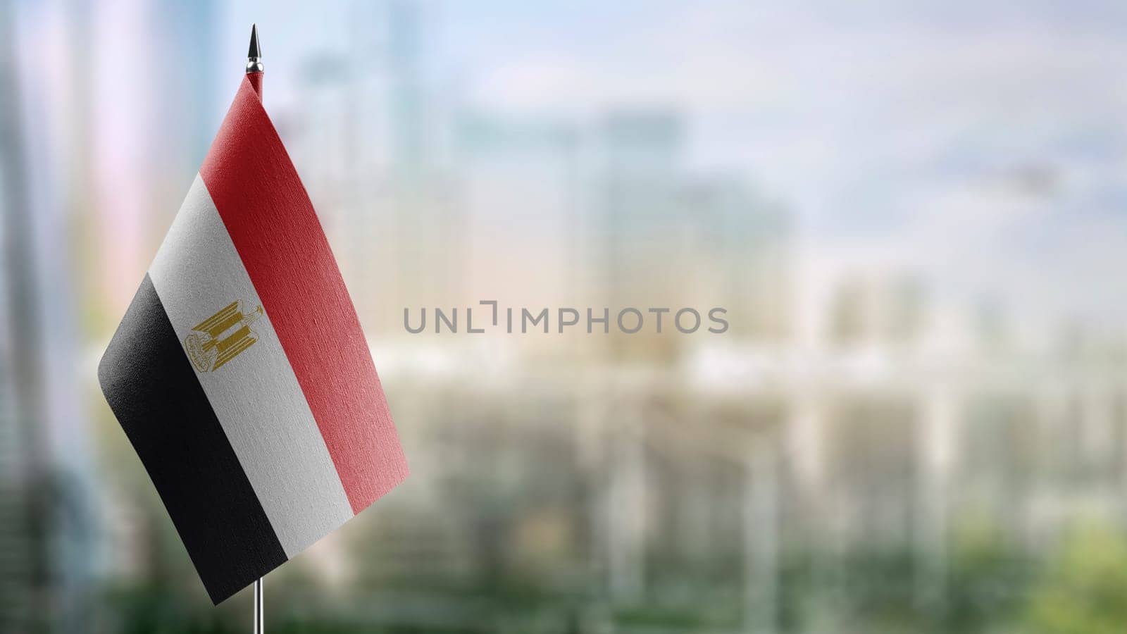 Small flags of the Egypt on an abstract blurry background.