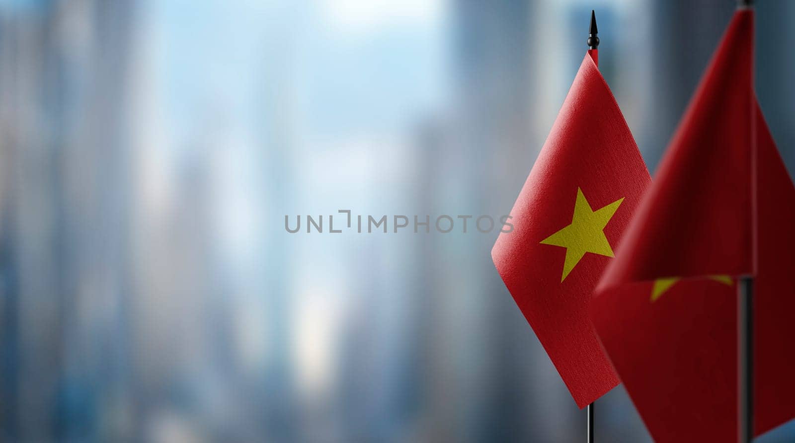 Small flags of the Vietnam on an abstract blurry background.