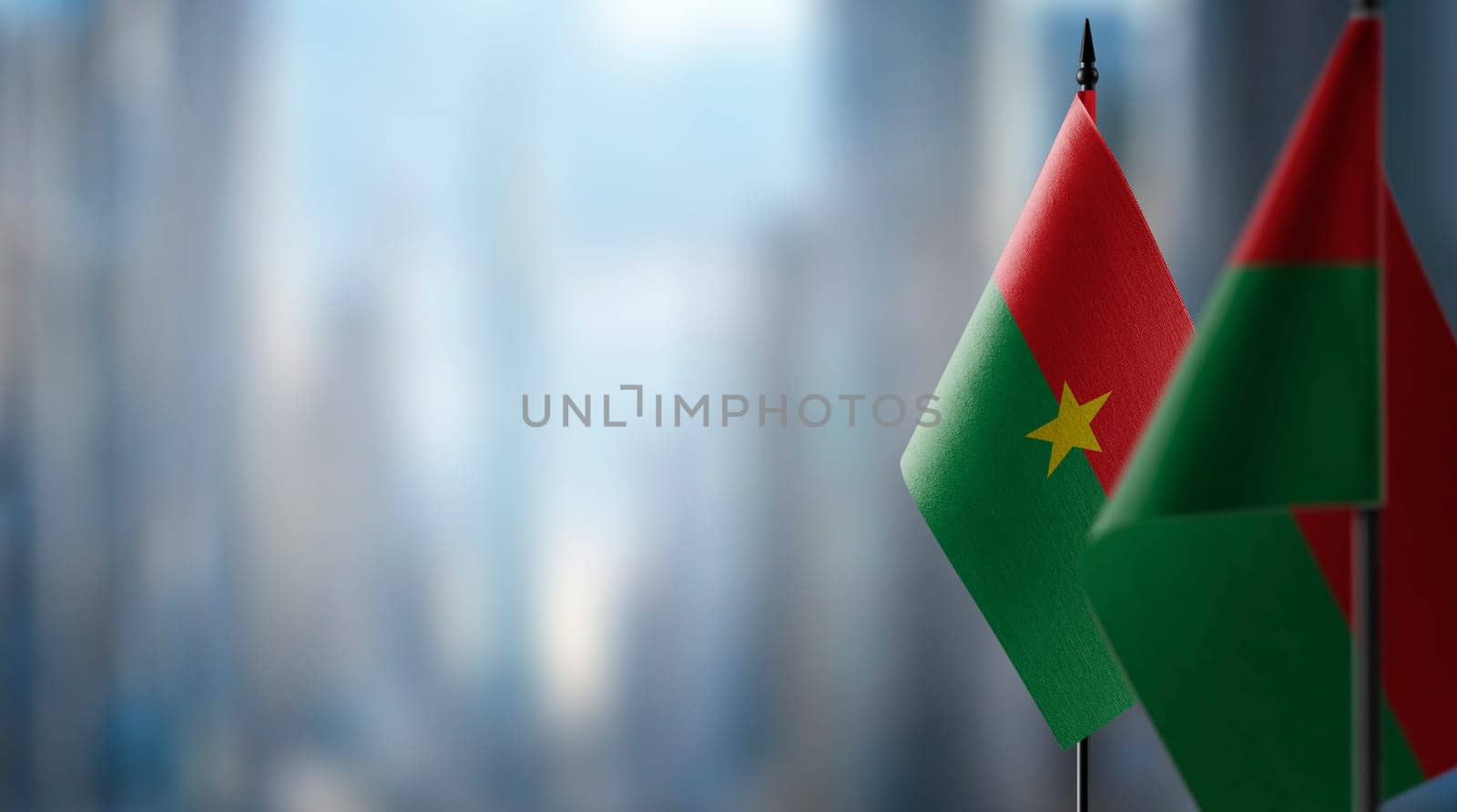 Small flags of the Burkina Faso on an abstract blurry background.
