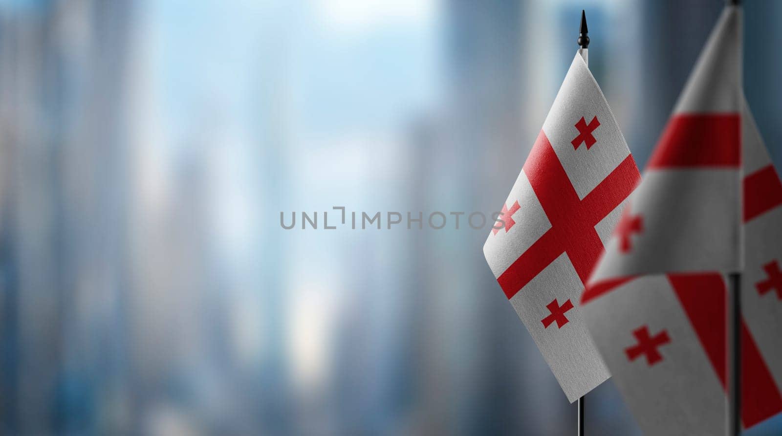Small flags of the Georgia on an abstract blurry background.
