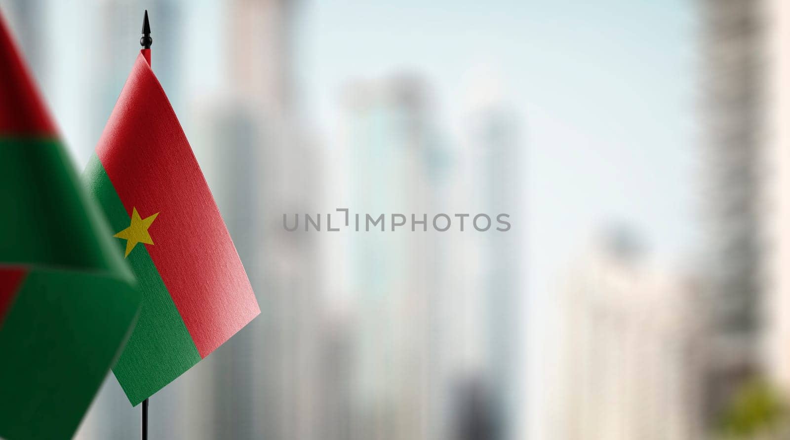 Small flags of the Burkina Faso on an abstract blurry background.
