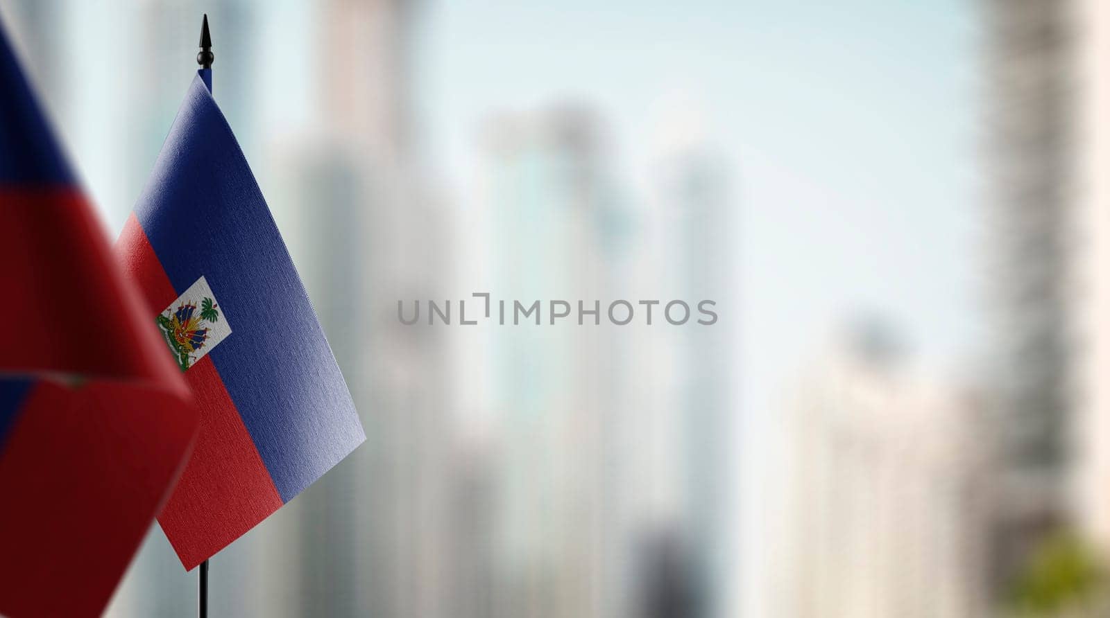 Small flags of the Haiti on an abstract blurry background.