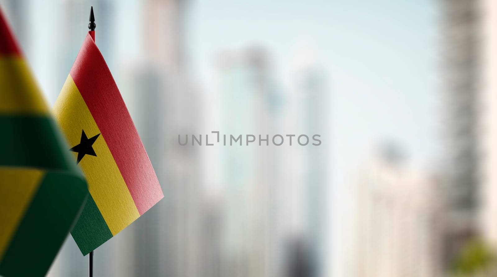 Small flags of the Ghana on an abstract blurry background.