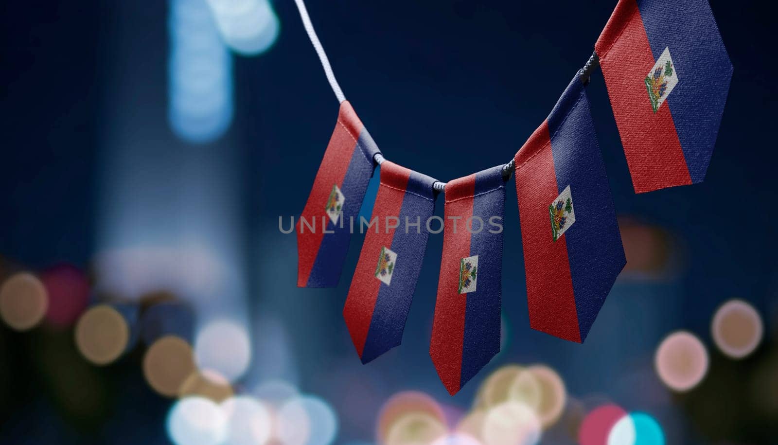 A garland of Haiti national flags on an abstract blurred background.