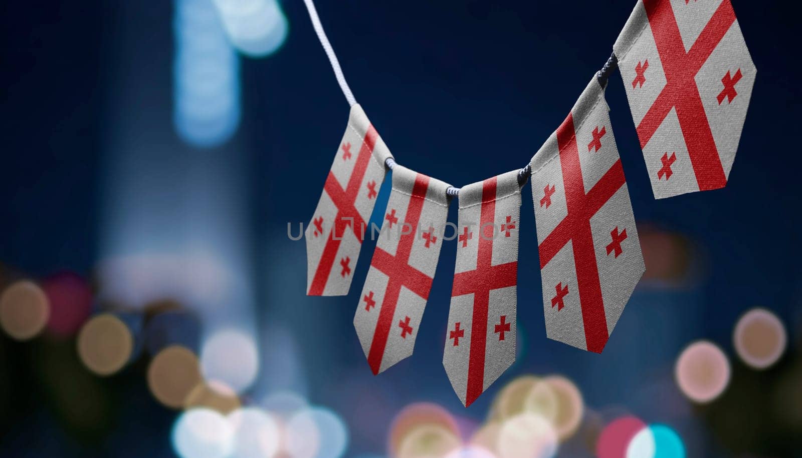 A garland of Georgia national flags on an abstract blurred background.