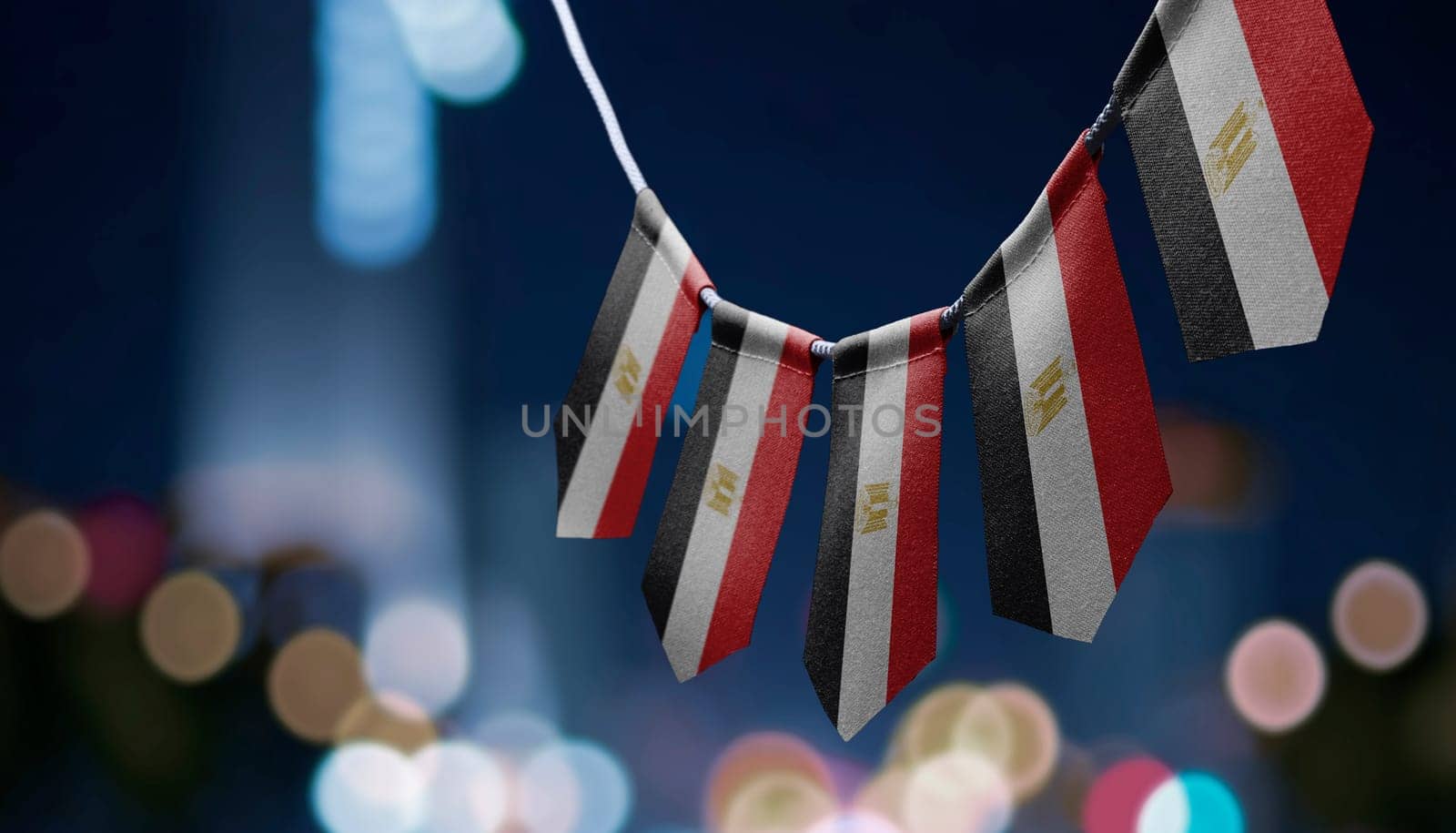 A garland of Egypt national flags on an abstract blurred background.