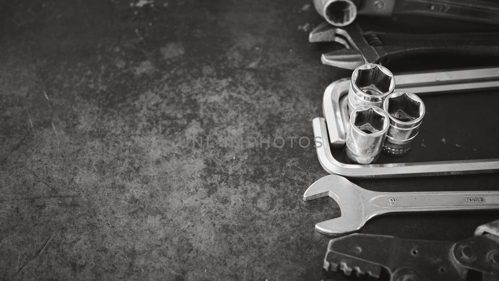 Hand tools consisting of wrenches, pliers, socket wrenches, laid out on old steel plate background. by Unimages2527