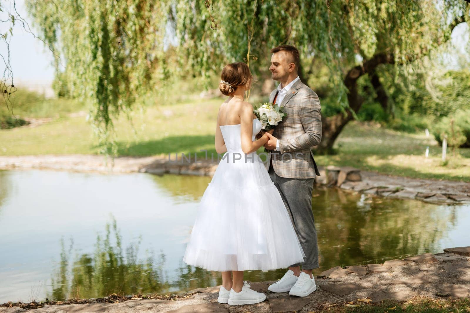 the first meeting of the bride and groom in wedding outfits in the park