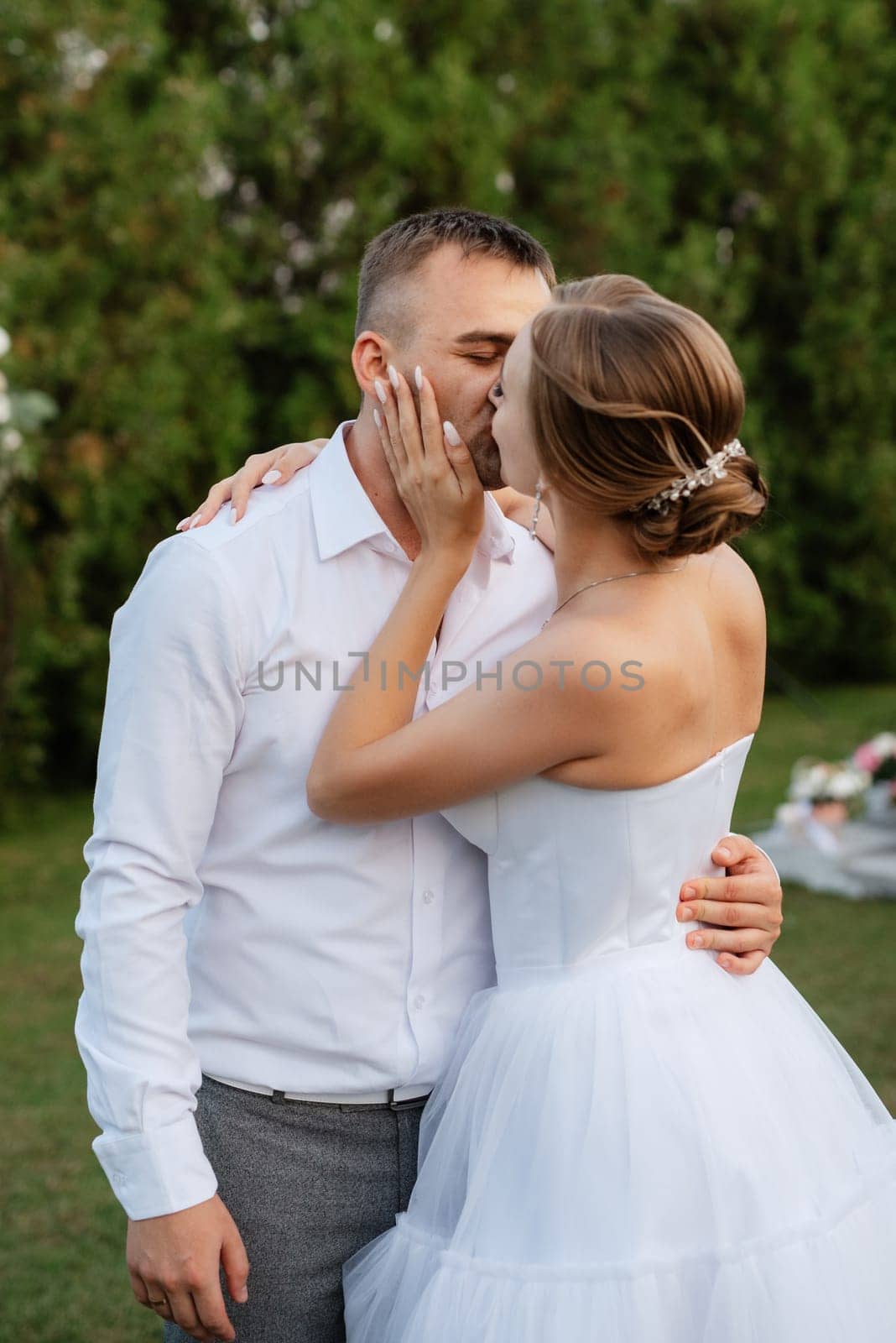 the first dance of the groom and bride in a short wedding dress on a green meadow by Andreua