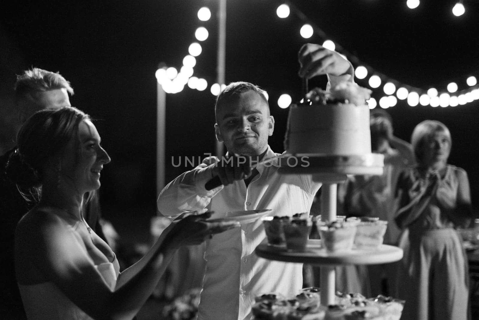 newlyweds happily cut and taste the wedding cake by Andreua