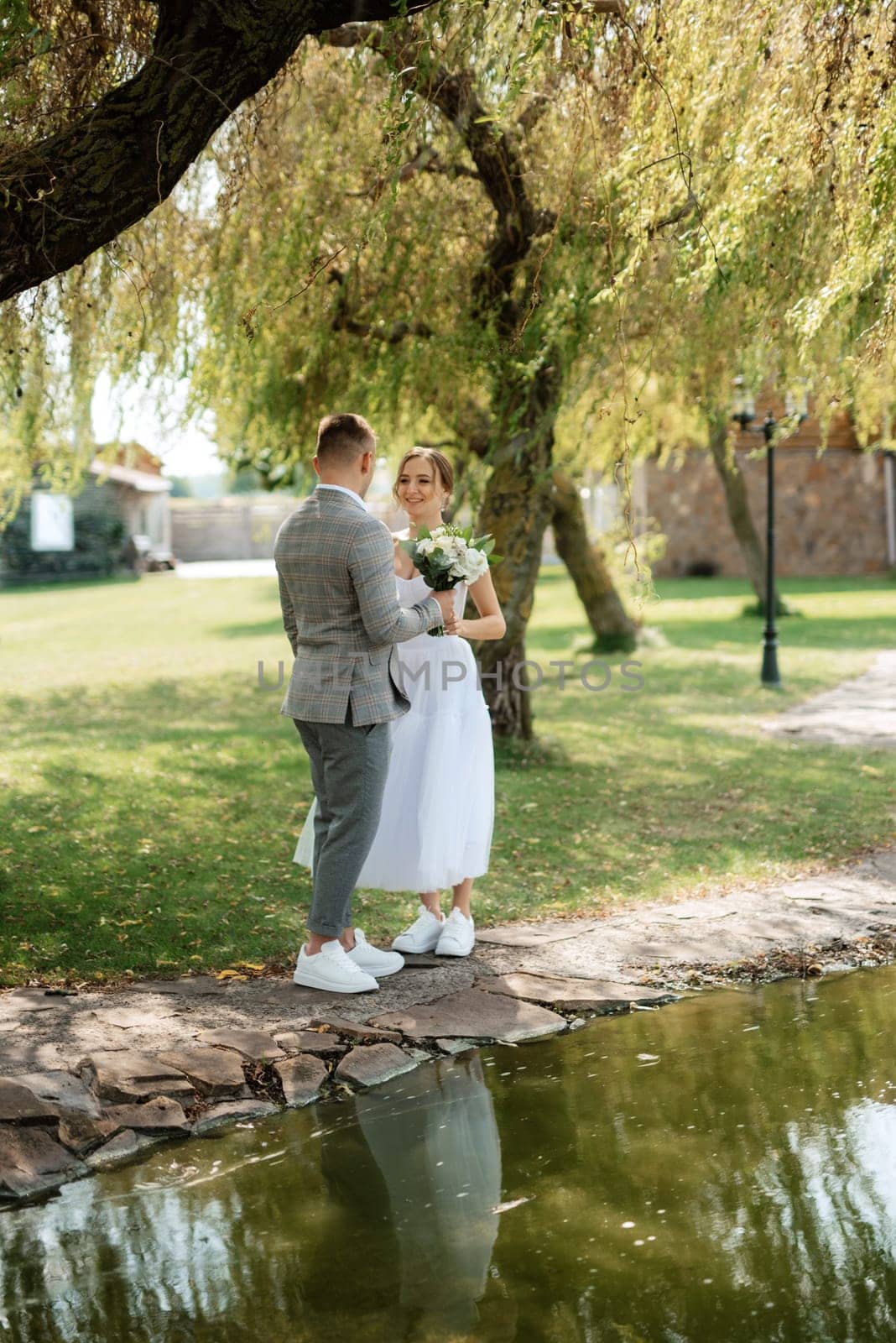 the first meeting of the bride and groom in wedding outfits in the park