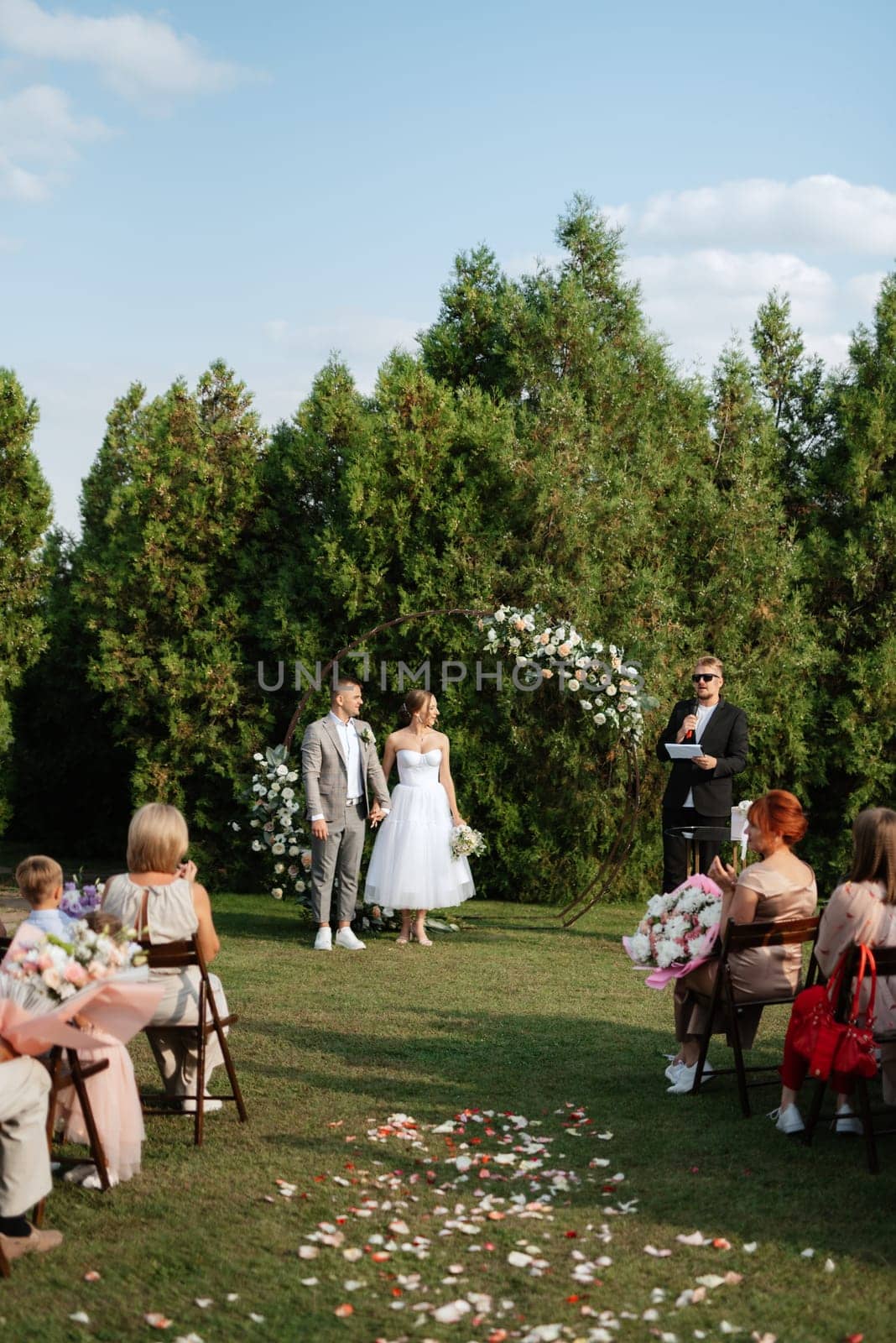 wedding ceremony of the newlyweds on the glade near the restaurant