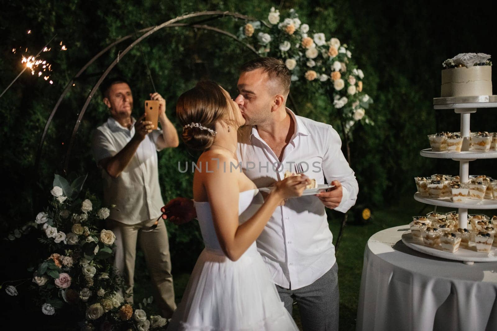 newlyweds happily cut and taste the wedding cake by Andreua