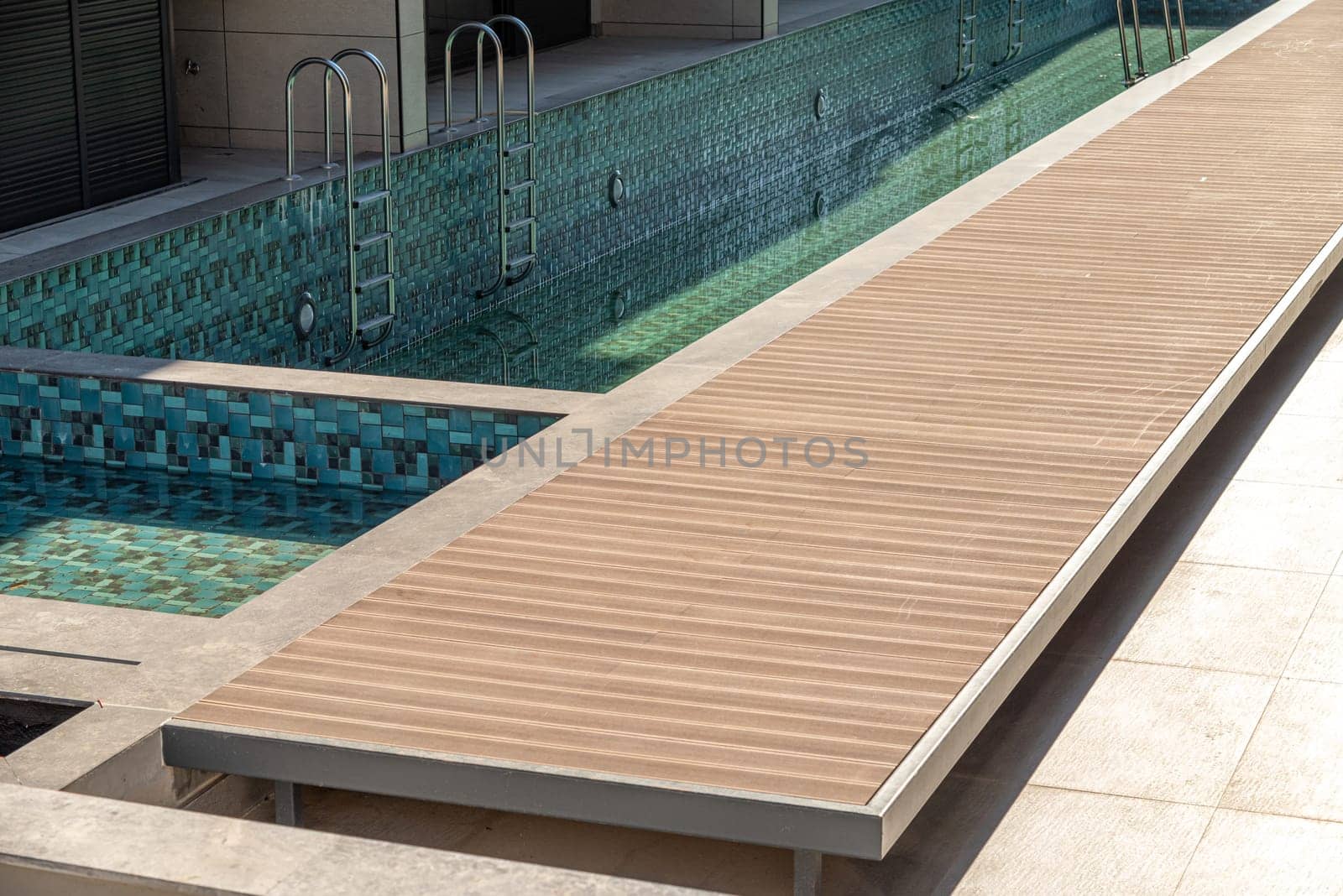 Composite deck installed on the edge of the swimming pool by Sonat
