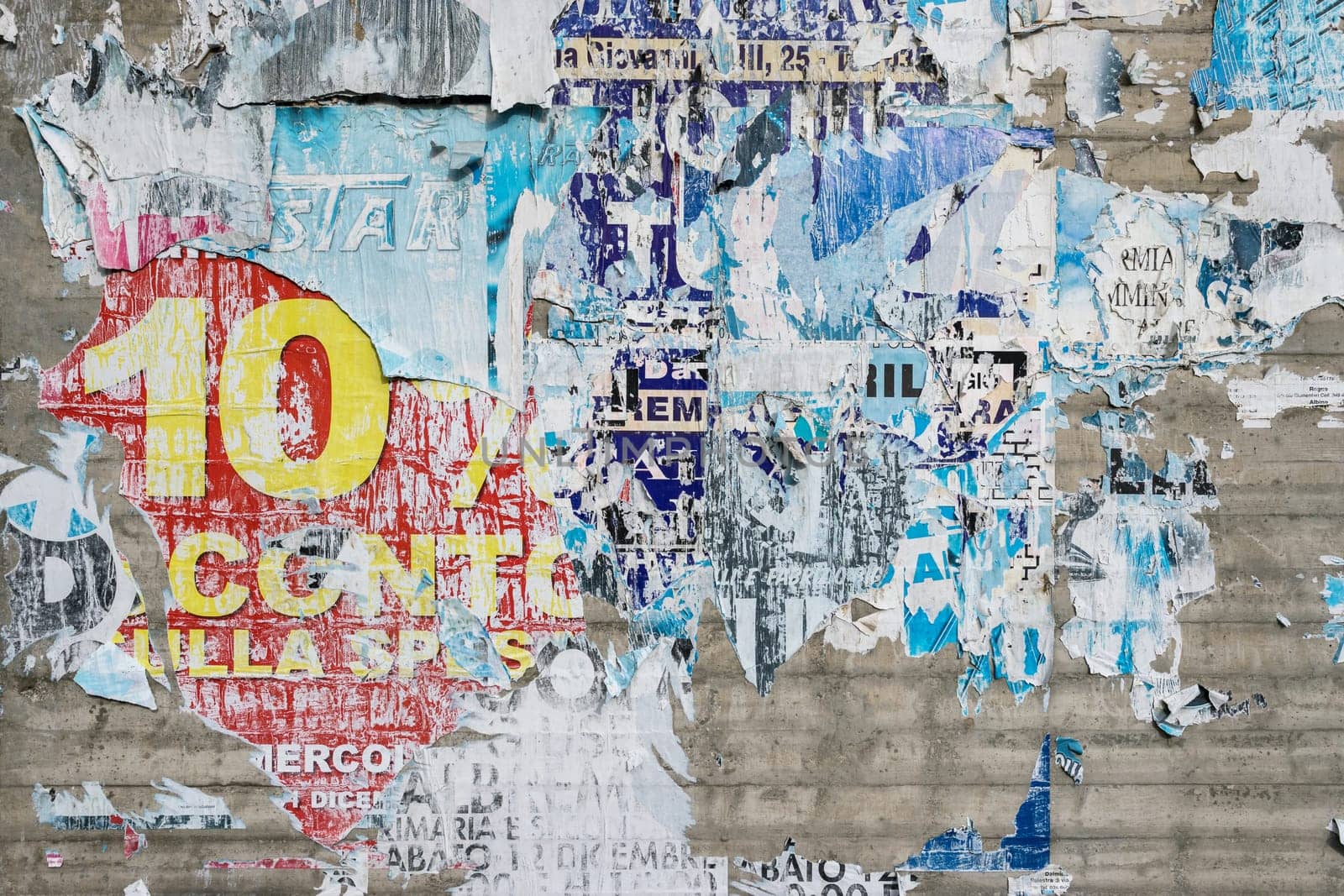Torn colorful posters on wall by germanopoli