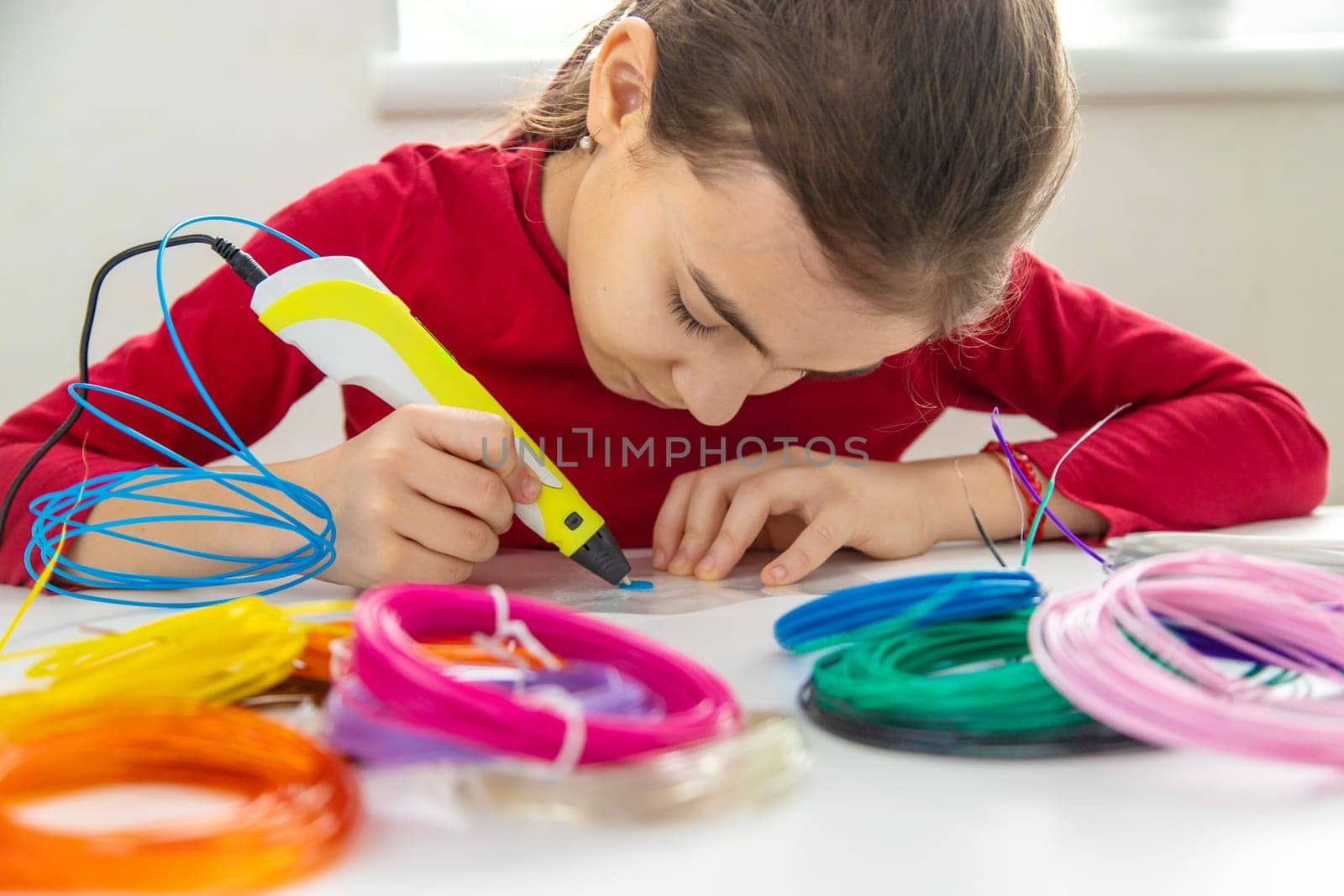 Child 3D drawings with a pen on the table. Selective focus. Kid.