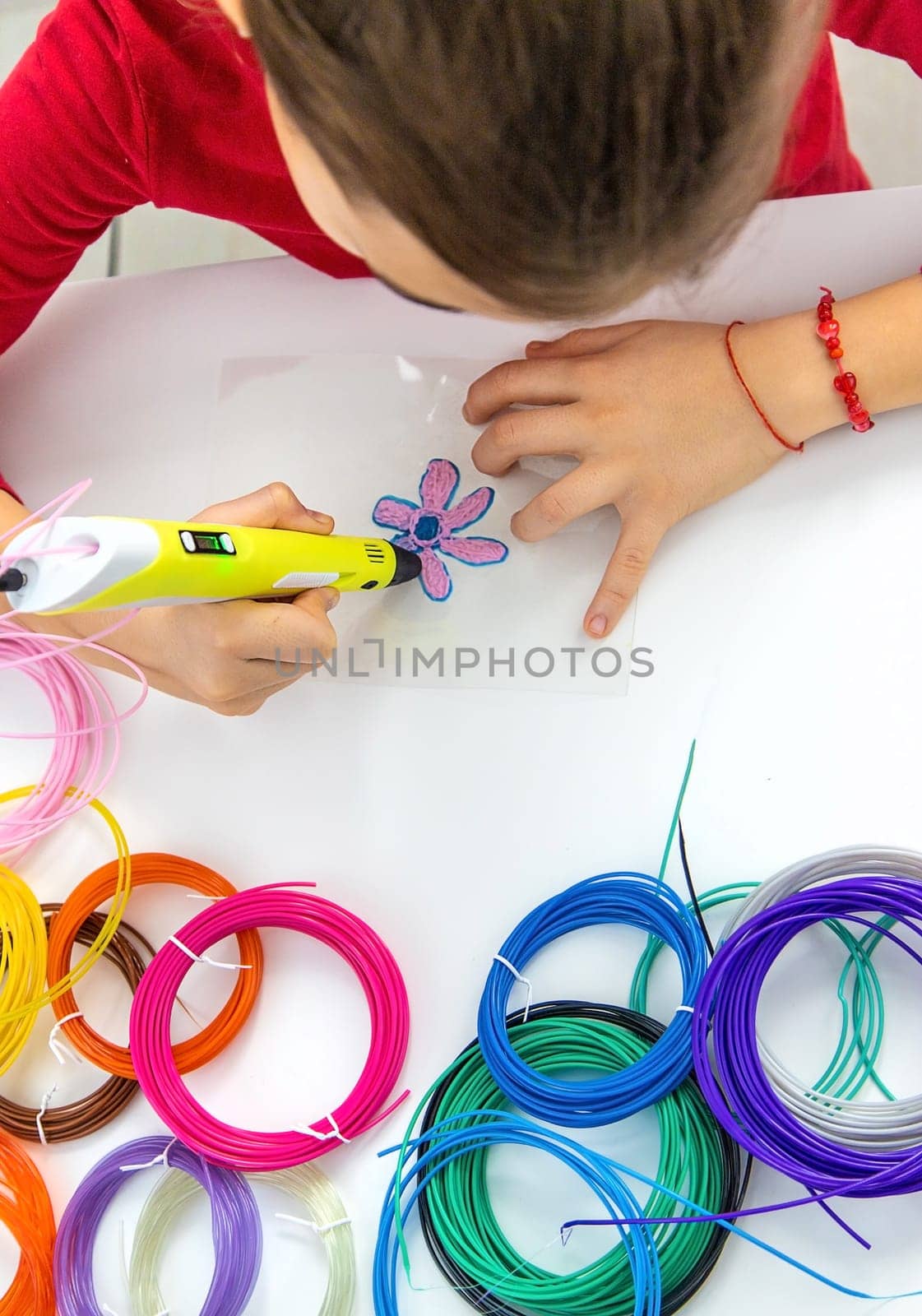 Child 3D drawings with a pen on the table. Selective focus. Kid.