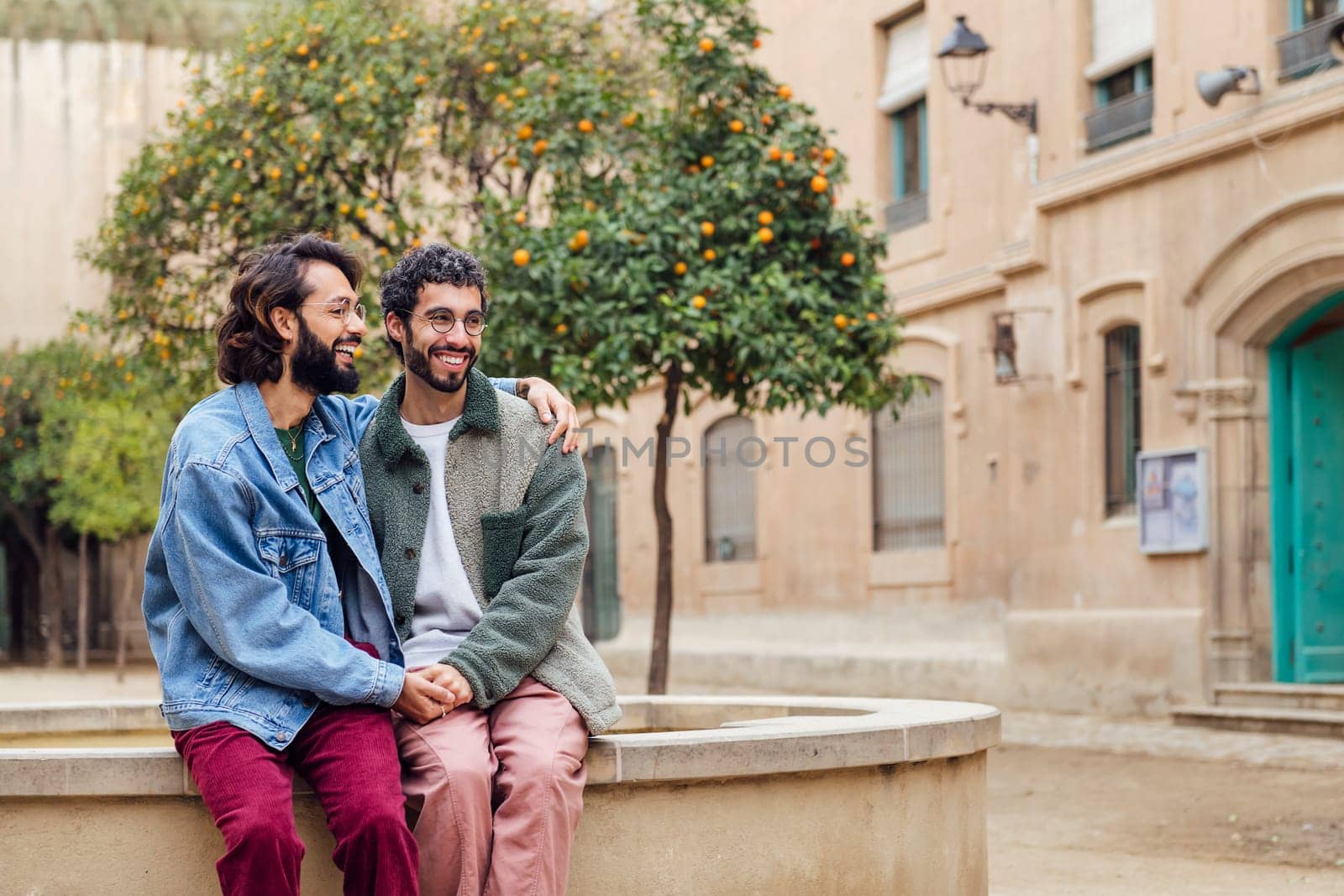 young couple of gay men smiling happy holding hands tenderly, concept of urban lifestyle and love between people of the same sex, copy space for text