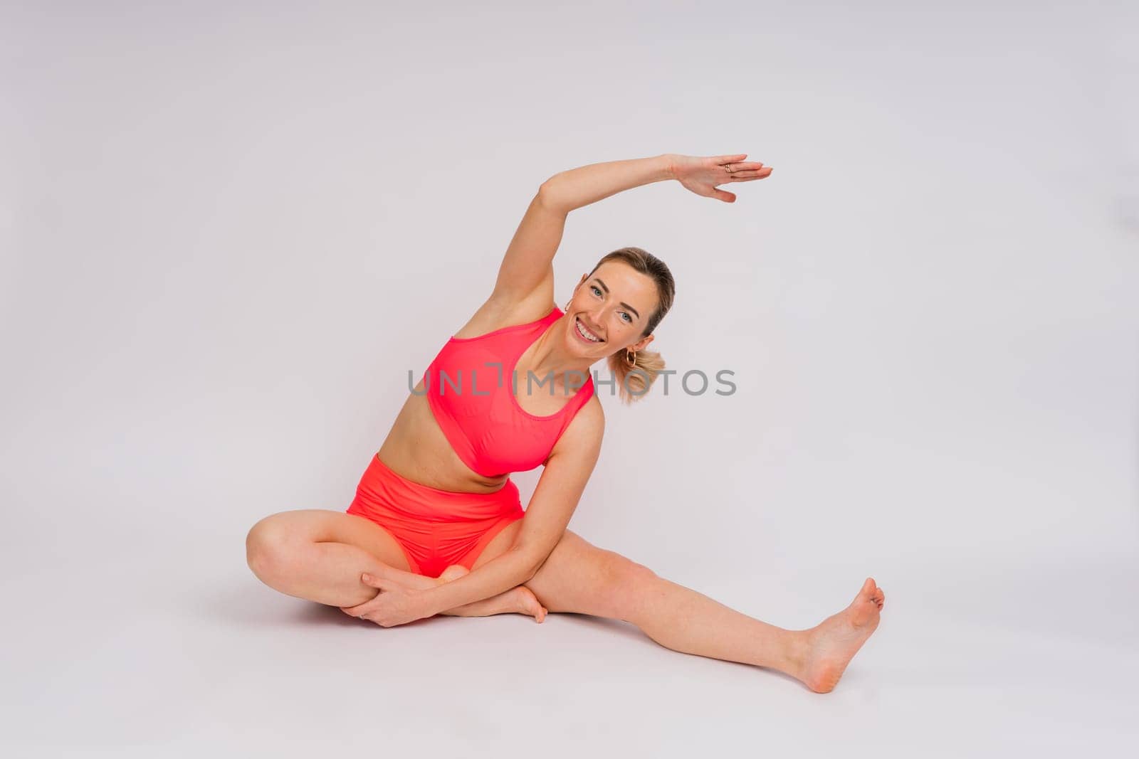 Beautiful female with dumbbells posing on a studio background