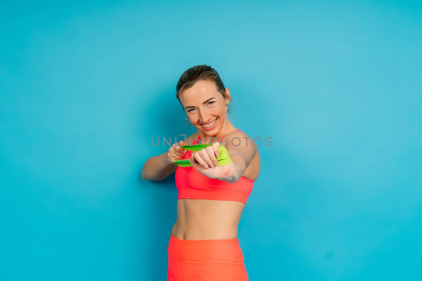 Beautiful female with dumbbells posing on studio background by Zelenin