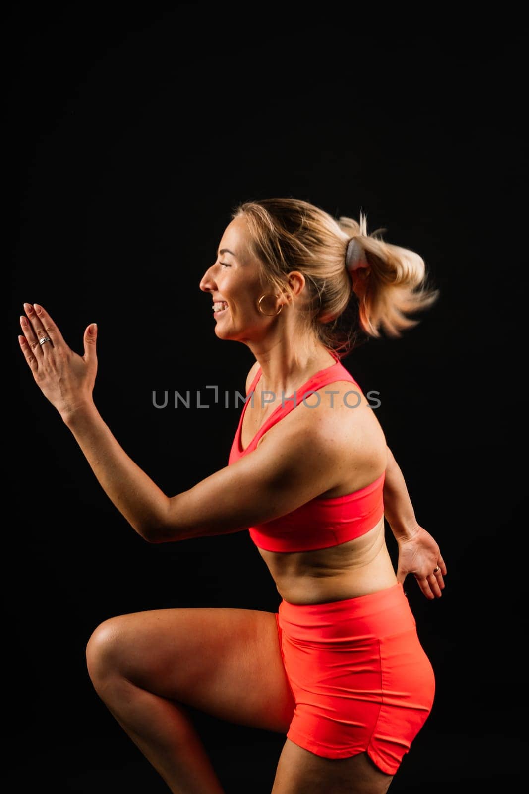 Beautiful female with dumbbells posing on studio background by Zelenin