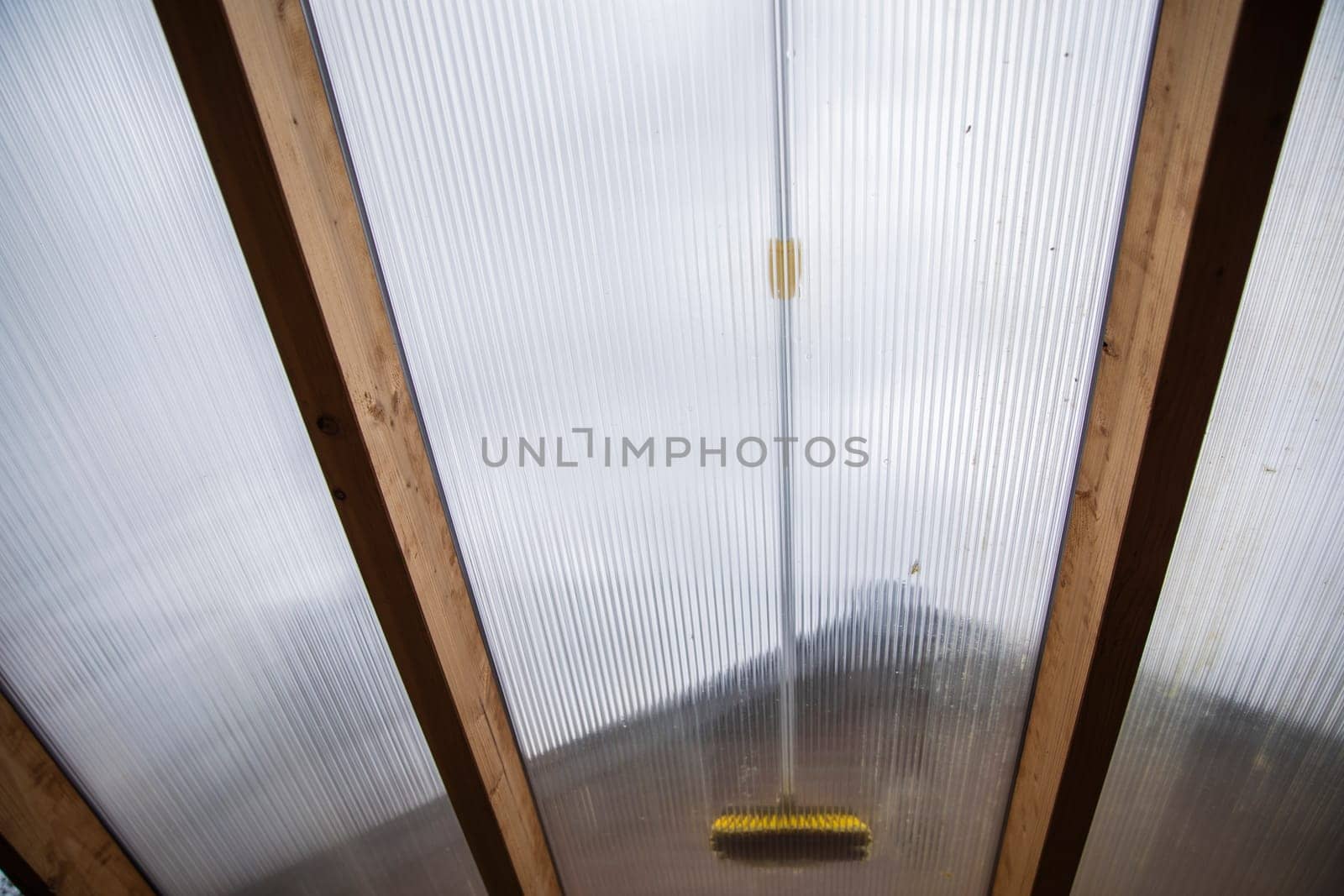 Washing the patio pergola roof cover made of aluminum. removing the dirty algae with brush soap and water close up in garden from a house terrace cleaning, workers, concept