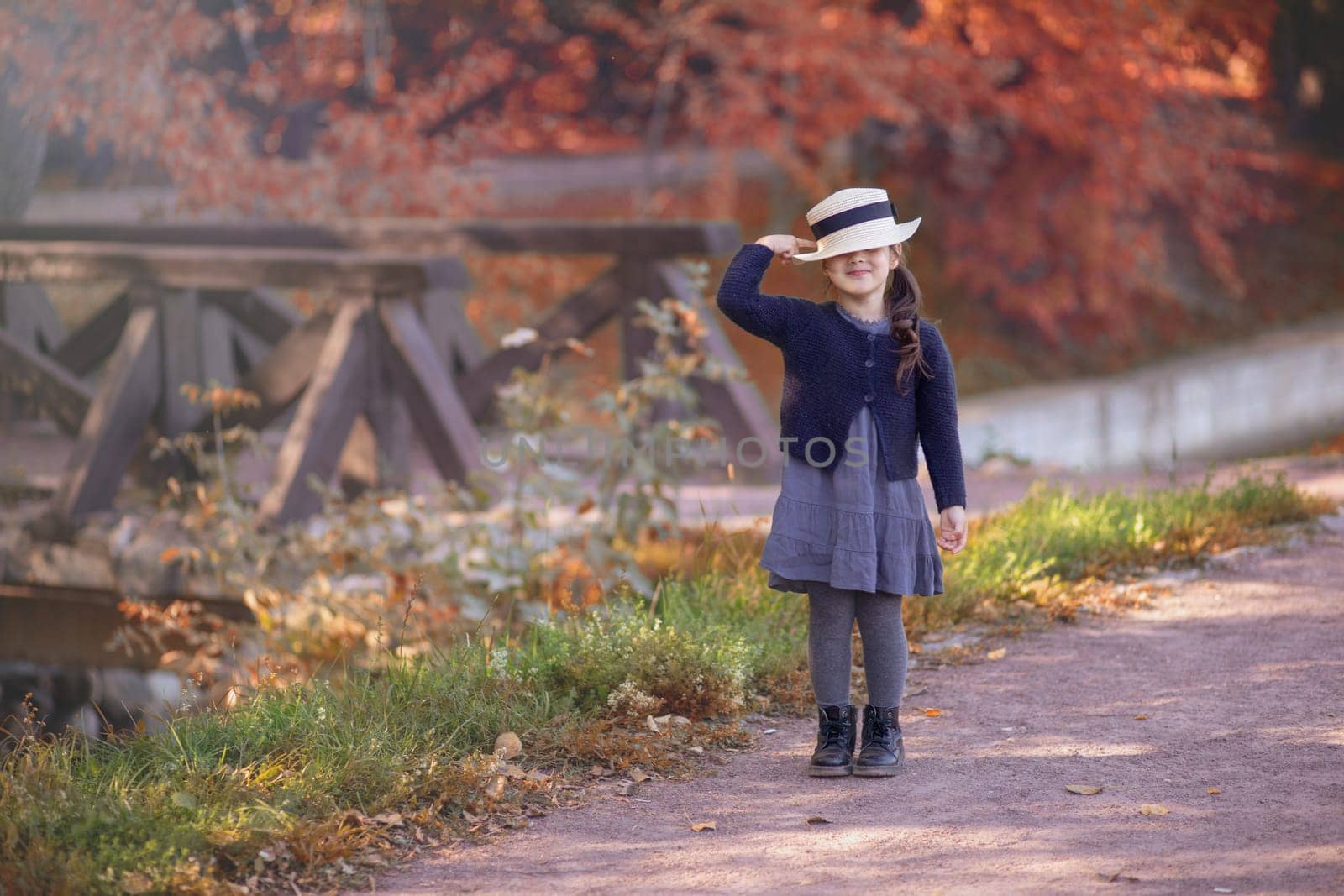 A funny little girl stands smiling in vintage clothing by Zakharova